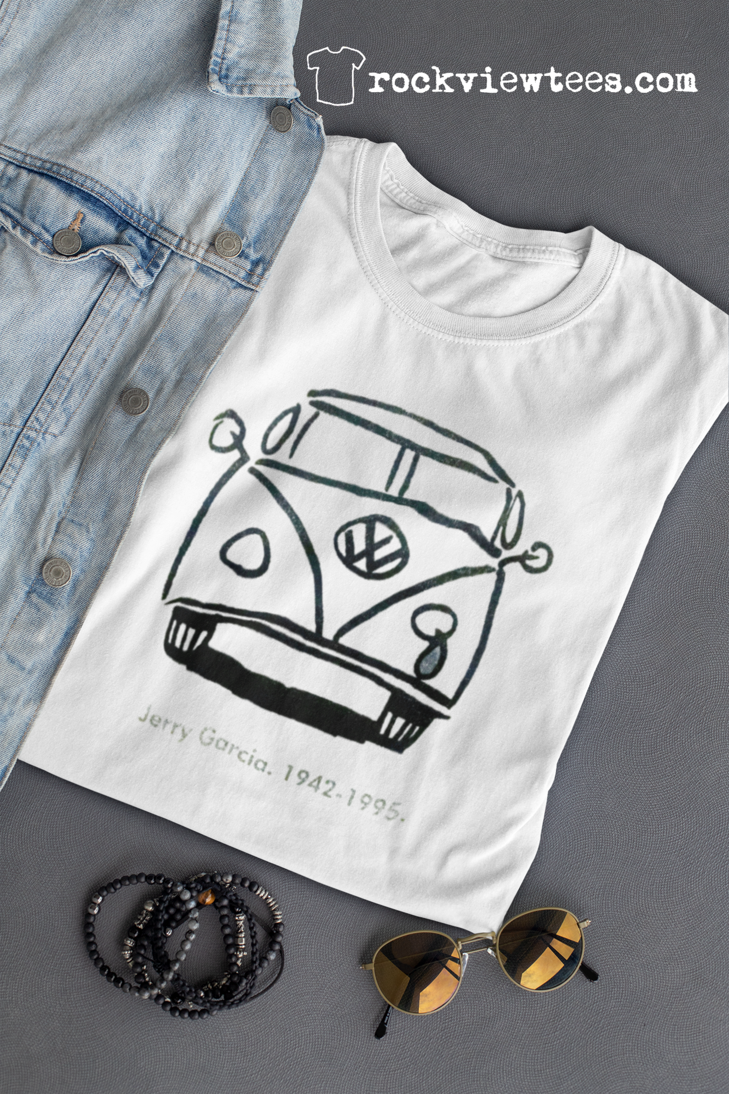 Folded Jerry Garcia VW bus t-shirt placed next to sunglasses highlighting the premium soft cotton construction and vintage aesthetic ideal for Dead & Company concerts and classic rock enthusiasts