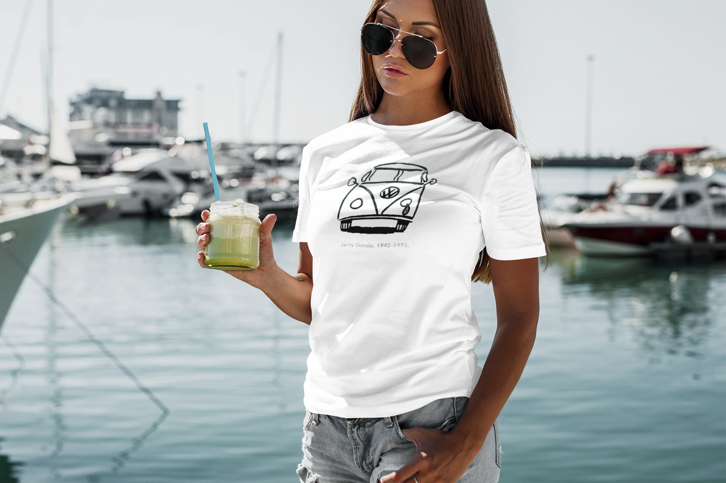Woman wearing Jerry Garcia VW bus tribute tee while enjoying a smoothie, showcasing the comfortable classic fit and retro-inspired design perfect for casual everyday wear and music festivals